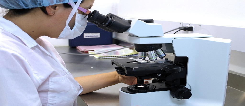 technician looking in microscope
